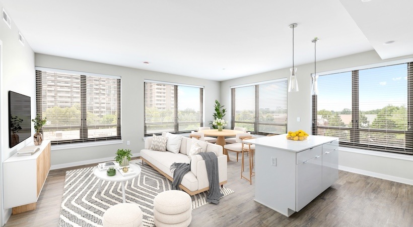 Model living room at Urba Apartments in Ballston, Arlington, VA, featuring wood grain floor paneling and a kitchen island.