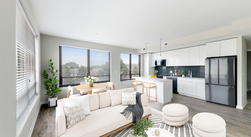 Model living room at Urba Apartments in Ballston, Arlington, VA, featuring wood grain floor paneling and a kitchen island.